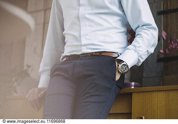 Midsection of businessman with hand in pocket leaning on sideboard in portable office truck