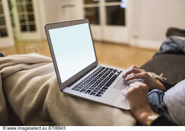Midsection of businesswoman working on laptop at home