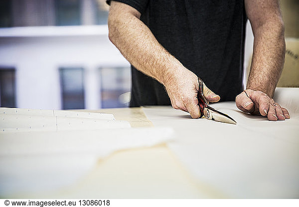 Midsection of fashion designer working at table in design studio