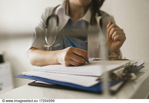 Midsection of female healthcare worker writing prescription