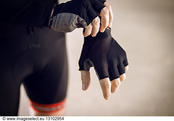 Midsection of male cyclist wearing glove outdoors
