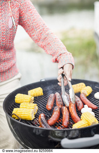Midsection of woman barbecuing outdoors