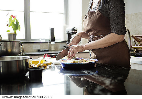 Midsection of woman cutting bananas for preparing tart