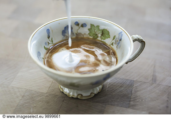 Milchschaum  der in eine Tasse Cappuccino tropft