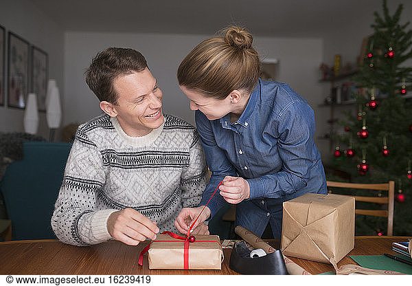 Mildes erwachsenes Paar verpackt Geschenke
