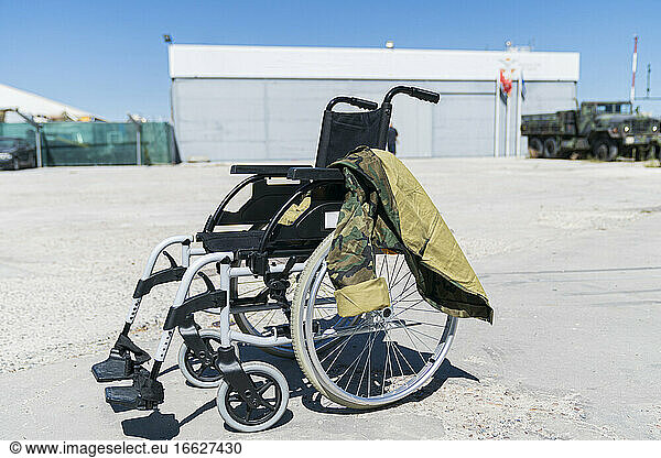 Military uniform on empty wheelchair at military base during sunny day