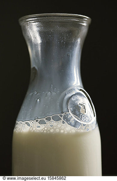 Milk in old bottle container with bubbles detail close up