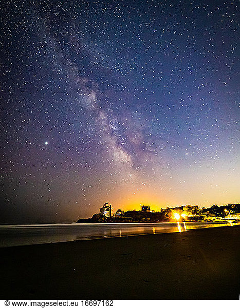 Milky way galaxy and stars in the night sky above beach houses.