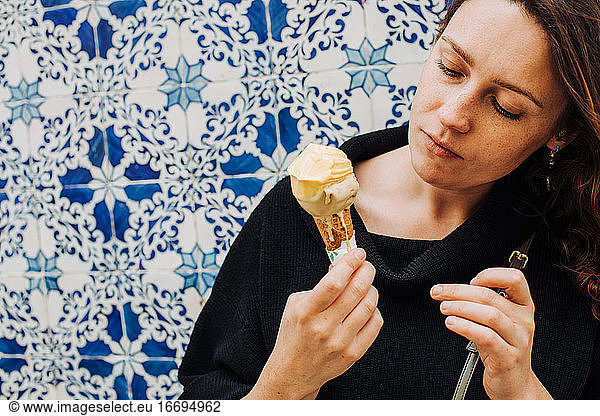 Millennial-Frau mit Sommersprossen schaut auf schmelzendes Eis