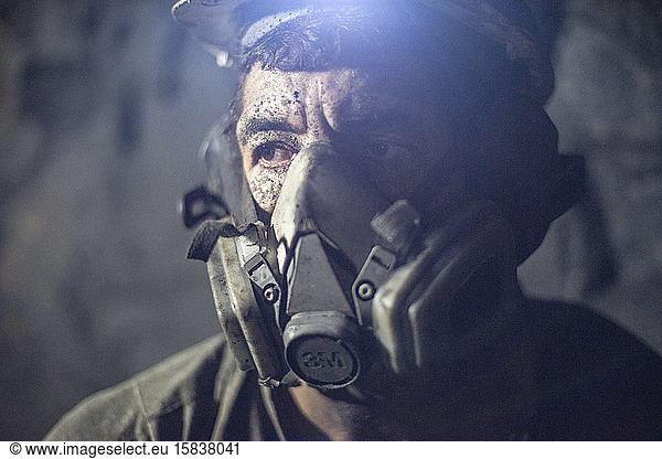 Miner at work using hardhat and dust mask