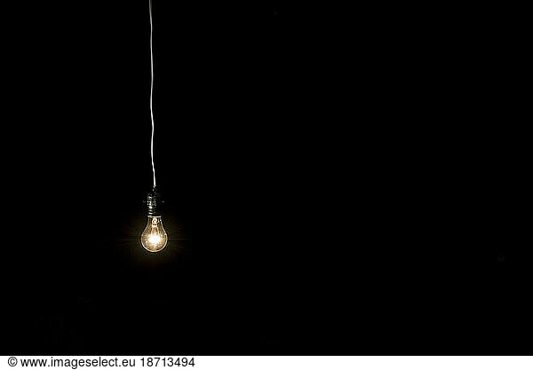 Minimalist view of light bulb and electrical cord.