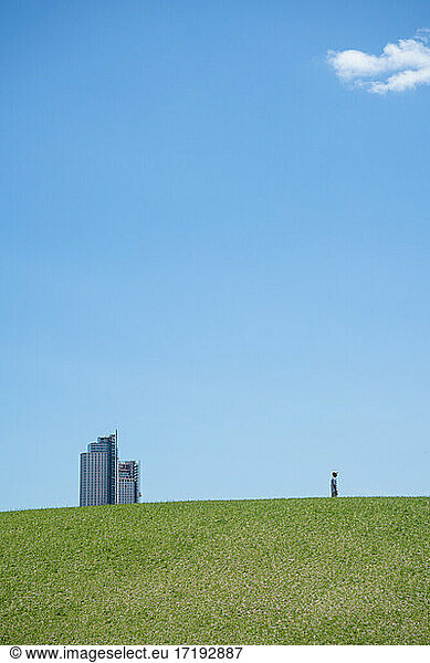Minimalistische Landschaftsarchitektur mit blauem Himmel und einer einzelnen Person