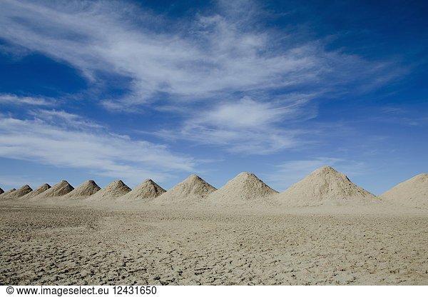 Mining tailings creating row of dirt piles in desert
