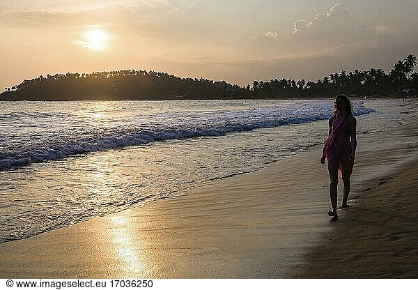 Mirissa  Frau im Urlaub am Strand von Mirissa bei Sonnenuntergang  Südküste von Sri Lanka  Südprovinz  Asien