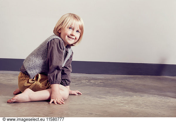 Mischievous girl kneeling on floor