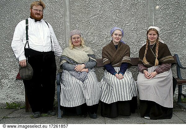 Mitarbeiter in historischen Kostümen  Mann steht  drei Frauen sitzen auf Bank  Freilichtmuseum Árbær  Reykjavík  Island  Europa