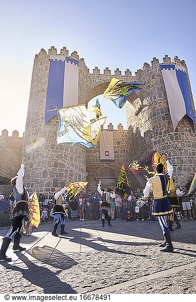 Mittelalterliche Tänzer werfen Fahnen neben der mittelalterlichen Stadtmauer von Avila. Avila  Spanien