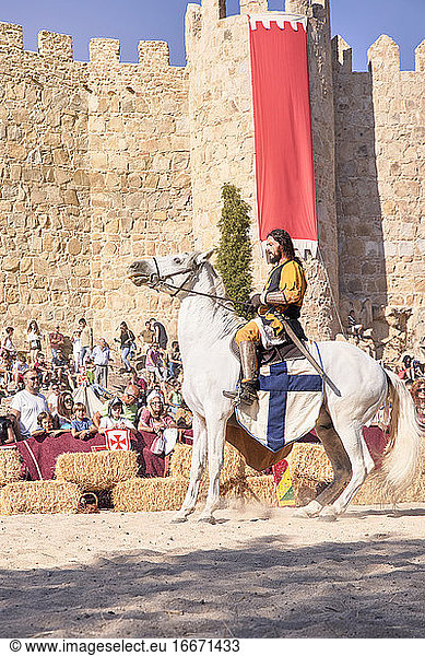 Mittelalterlicher Ritter auf seinem Pferd neben der Stadtmauer während der mittelalterlichen Festlichkeiten. Avila  Spanien