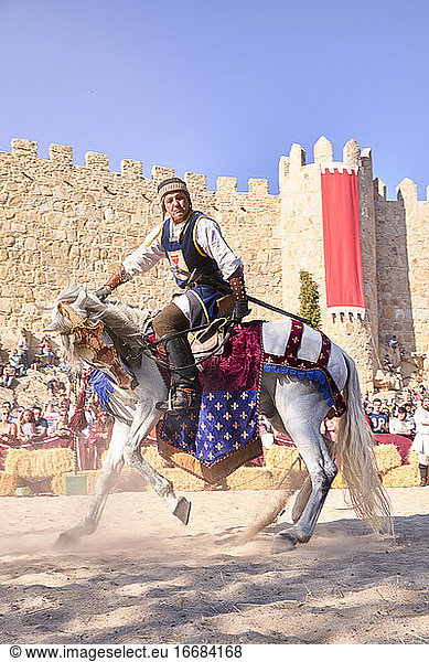 Mittelalterlicher Ritter auf seinem Pferd neben der Stadtmauer während der mittelalterlichen Festlichkeiten. Avila  Spanien