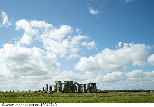 Mitteldistanzansicht von Stonehenge auf dem Feld gegen bewölkten Himmel