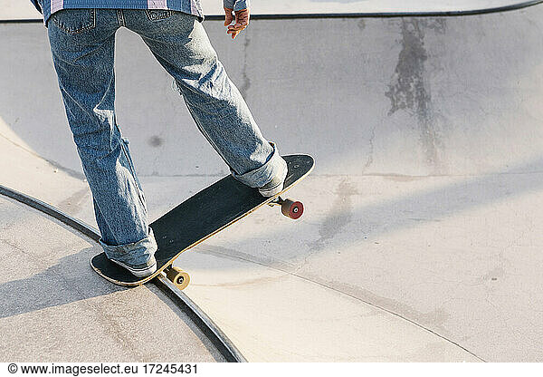 Mittlere erwachsene Frau balanciert auf Skateboard