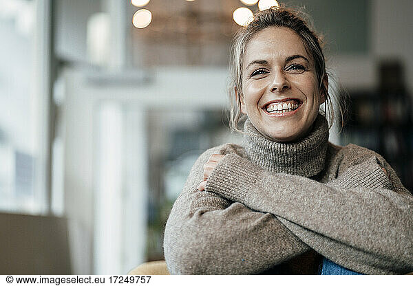 Mittlere erwachsene Frau im Pullover  lächelnd im Cafe