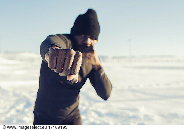 Mittlerer erwachsener Sportler beim Sport im Schnee an einem sonnigen Tag