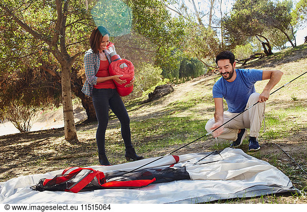 Mittleres erwachsenes Ehepaar zeltet  baut sein Zelt auf