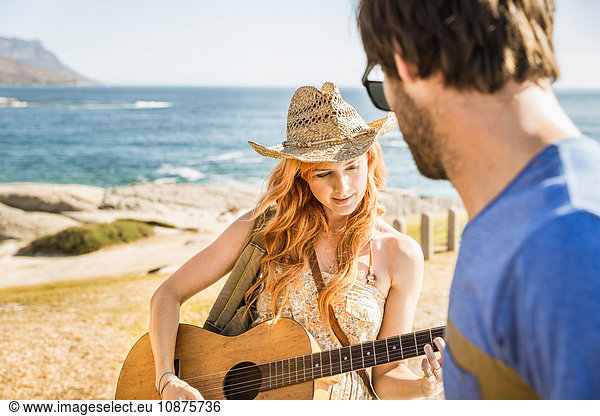 Mittleres erwachsenes Paar an der Küste  das Gitarre spielt  Kapstadt  Südafrika