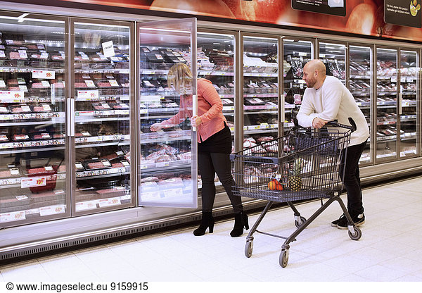 Mittleres erwachsenes Paar beim Einkaufen im Supermarkt