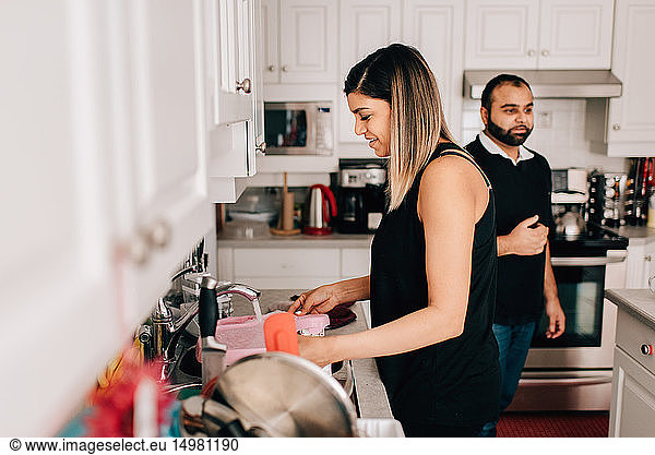 Mittleres erwachsenes Paar in der Küche beim Geschirrspülen