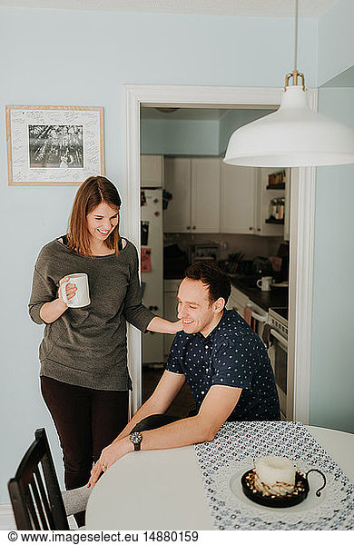 Mittleres erwachsenes Paar macht Kaffeepause am Küchentisch