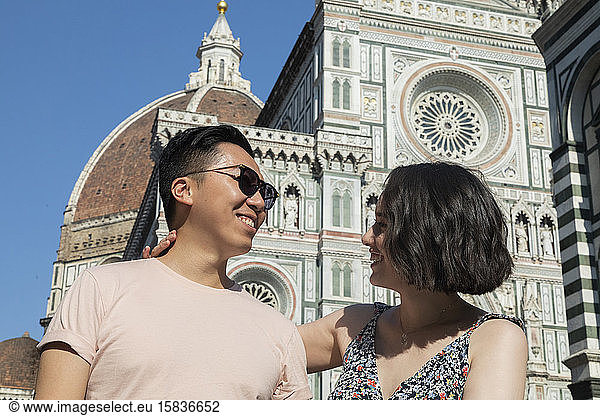 Mixed ethnicity couple smiling in front of the Duomo in Florence Italy