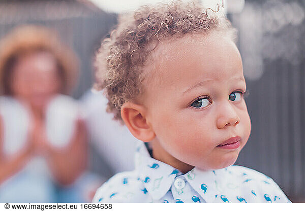 Mixed race baby boy with blue eyes looking at camera