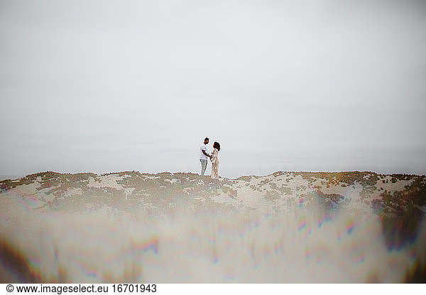 Mixed Race Couple Posing on Sand Dunes with Prism Effect