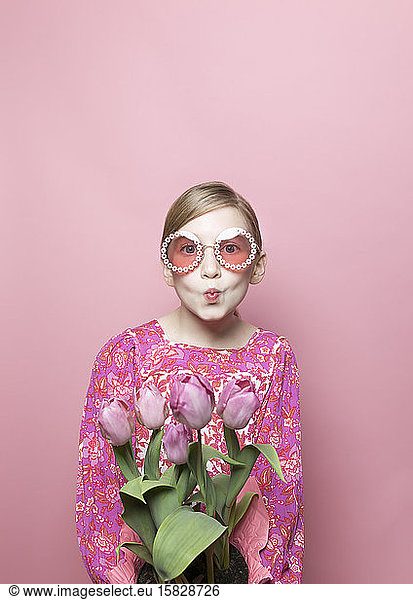 Mod blondes Tween Girl  blaue Redaktion  rosa Hintergrund  rosa Blumenkleid