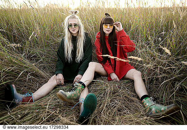 Mode Zwillingsmädchen posieren in heller Kleidung auf dem Feld