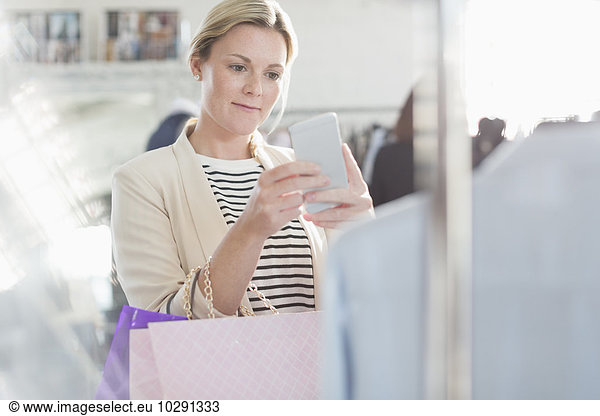 Modedesigner fotografiert Kleidung mit Fotohandy