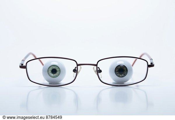 Model eyeballs behind spectacles with myopic (negative) lenses