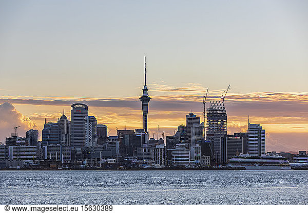 Modern buildings by sea against cloudy sky at sunset  Oceania  New Zealand