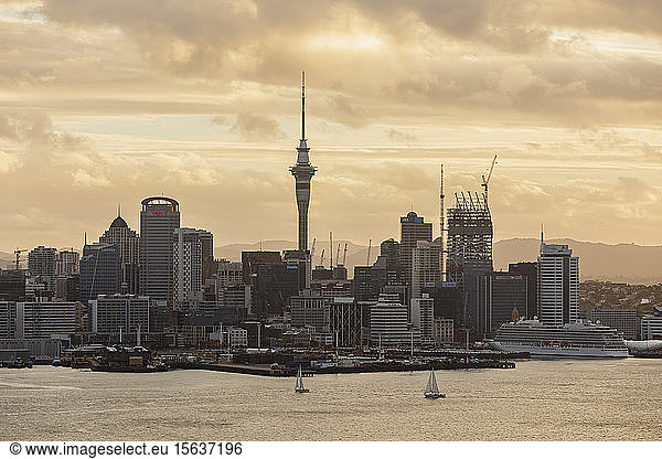 Modern buildings by sea against cloudy sky during sunset  Oceania  New Zealand