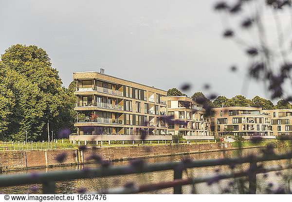Modern buildings by Trave river against sky in LÃ¼beck  Germany