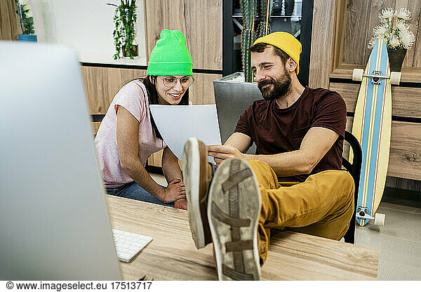 Modern business couple reading document in office