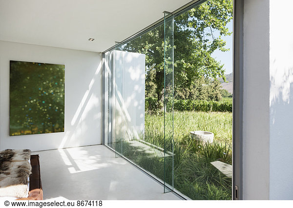 Modern house with glass walls overlooking grass
