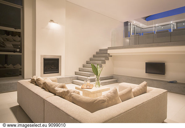 Modern living room with balcony illuminated at night