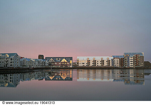 Modern residential district near calm river in evening