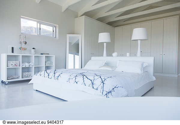 Modern white bedroom interior with double bed