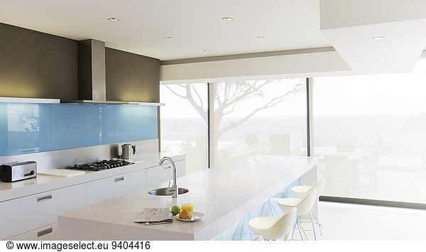 Modern white kitchen with kitchen island and stools