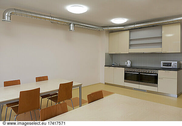 Modern youth hostel building. Kitchen and eating areas. Two ovens  kettle and toaster.