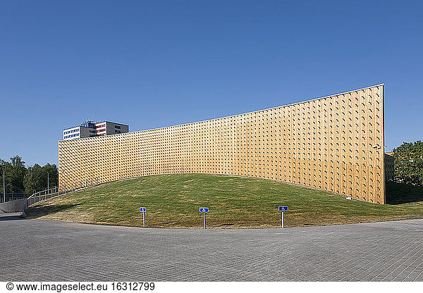 Moderne Universitätsgebäude  Holzbalken  die aus einer gebogenen Holzverkleidungswand herausragen  auf einer gekrümmten Grundfläche